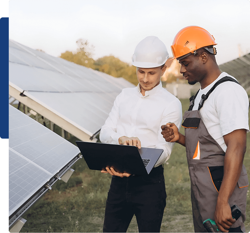 Two workers inspecting solar panels outdoors.